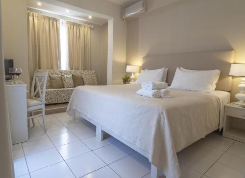 a bedroom with a white bed with towels on it at Kenta Beach Hotel in Agios Ioannis Pelio