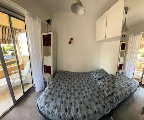 1 dormitorio con cama y ventana grande en Résidence Jardins Du Soleil - 2 Pièces pour 4 Personnes 754, en Six-Fours-les-Plages