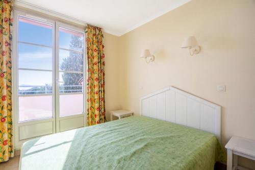 une chambre avec un lit et une grande fenêtre dans l'établissement Les Appartements aux Restanques du Golfe de St Tropez - maeva Home - Appartement duplex 3 Pièces 6 Personnes - Confort - vue Mer MAE-7771, à Grimaud