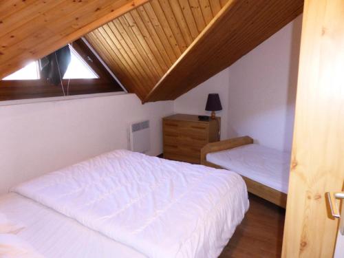 a bedroom with two beds and a wooden ceiling at Résidence Combettes - 3 Pièces pour 5 Personnes 324 in Les Contamines-Montjoie