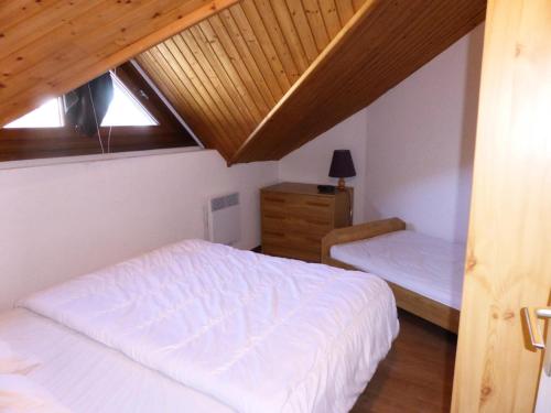 une chambre avec deux lits et un plafond en bois dans l'établissement Résidence Combettes - Les Combettes D258 MAE-0324, aux Contamines-Montjoie