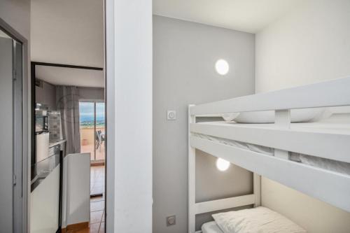 une chambre avec un lit superposé et un miroir dans l'établissement Village Pont Royal en Provence - maeva Home - Appartement moderne climatisé 4 pièces 8 personnes - Sélection - super Home MAE-8568, à Mallemort