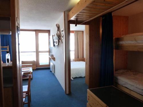 Zimmer mit 2 Etagenbetten, einem Schreibtisch und einem Tisch in der Unterkunft Résidence Nova - 2 Pièces pour 6 Personnes 214 in Arc 1800
