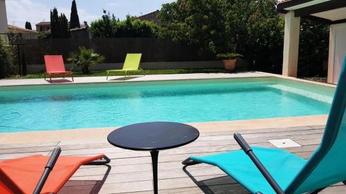 una piscina con sillas y una mesa junto a ella en Résidence Courtaude - 3 Pièces pour 5 Personnes 864, en Six-Fours-les-Plages