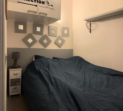 een slaapkamer met een bed en foto's aan de muur bij Résidence Luberon Loisir - 2 Pièces pour 4 Personnes 834 in Six-Fours-les-Plages