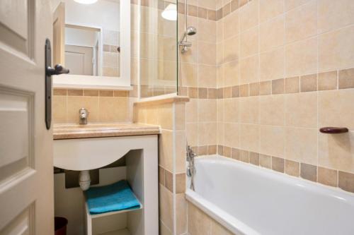 une salle de bain avec une baignoire et un lavabo et une baignoire dans l'établissement Village Le Rouret - maeva Home - Appartement 2 Pièces 4 Personnes - Confort MAE-8018, à Grospierres