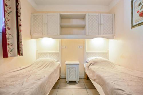 une chambre avec deux lits et une petite table dans l'établissement Village Le Rouret - maeva Home - Appartement 2 Pièces 4 Personnes - Confort MAE-8018, à Grospierres