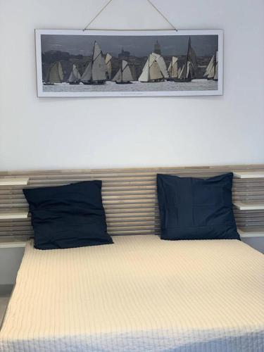 - un lit avec des oreillers bleus et une photo au-dessus dans l'établissement Résidence Mistral - Joli studio à Six Fours Les Plages 100m de la plage - Accès direct MAE-8844, à Six-Fours-les-Plages