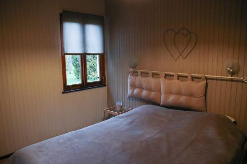a bedroom with a large bed with a heart on the wall at Chalet au bord de l’eau in Saint-Quirin
