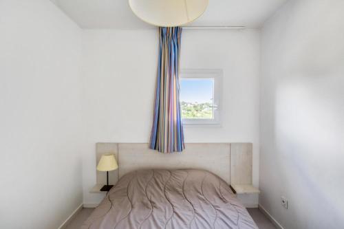 - une chambre avec un lit doté d'une fenêtre et d'un rideau dans l'établissement Residence Debussy - maeva Home - Appartement 2 Pièces 4 Personnes - Budget MAE-9028, à Carnoux-en-Provence