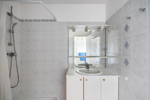 une salle de bain blanche avec un lavabo et une douche dans l'établissement Residence Debussy - maeva Home - Appartement 2 Pièces 4 Personnes - Budget MAE-9028, à Carnoux-en-Provence