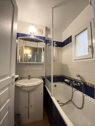 une salle de bain avec un lavabo, une baignoire et un miroir dans l'établissement Résidence Rivages - Agréable appartement 2 pièces dans domaine arboré en front de mer avec piscine MAE-8054, à Six-Fours-les-Plages