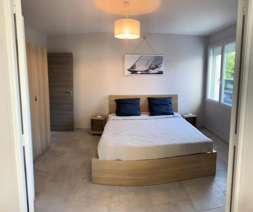 une chambre avec un lit avec des oreillers bleus dessus dans l'établissement Résidence Mistral - Appartement 6 couchages à 100m de la mer à Six Fours Les Plages MAE-8864, à Six-Fours-les-Plages