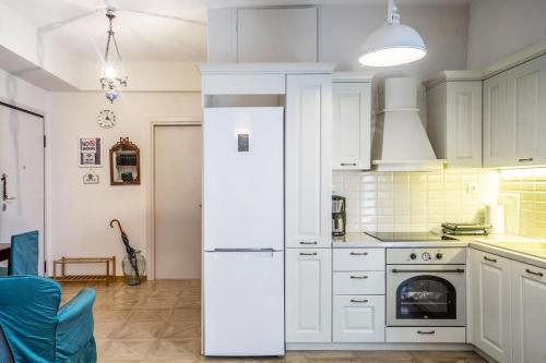 a kitchen with white cabinets and a white refrigerator at Lovely 1 Bd apt in Kalithea with Balcony in Athens