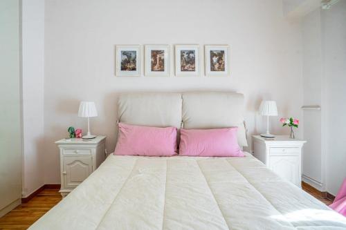a bedroom with a large white bed with pink pillows at Lovely 1 Bd apt in Kalithea with Balcony in Athens