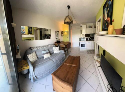 un salon avec un canapé et une table dans l'établissement Résidence Cap Vert - APPARTEMENT FRONT DE MER DANS DOMAINE AVEC PISCINE ET TENNIS MAE-8984, à Six-Fours-les-Plages