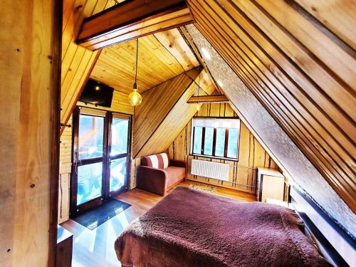 Zimmer im Dachgeschoss mit einem Bett und einem Sofa in der Unterkunft Lavanda cottage in Werchowyna