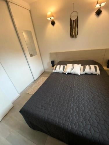 - une chambre avec un grand lit noir et deux oreillers dans l'établissement Residence Debussy - maeva Home - Appartement 2 Pièces 4 Personnes - Sélection MAE-9039, à Carnoux-en-Provence