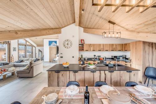Il comprend une cuisine ouverte et un salon doté de plafonds en bois. dans l'établissement Résidence Les Terrasses De La Vanoise - 7 pièces duplex 14 personnes 5 MAE-9204, à Champagny-en-Vanoise