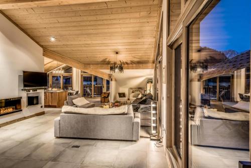 un salon avec un canapé, des chaises et des fenêtres dans l'établissement Résidence Les Terrasses De La Vanoise - 7 pièces duplex 14 personnes 5 MAE-9204, à Champagny-en-Vanoise