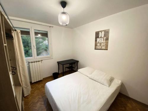 une chambre avec un lit blanc et une fenêtre dans l'établissement Résidence Rouviere - Grand appartement 8 couchages vue mer budget maitrisé MAE-9674, à Marseille