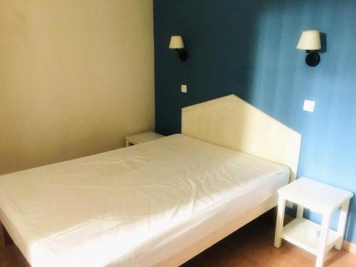 ein Schlafzimmer mit einem weißen Bett und einer blauen Wand in der Unterkunft Résidence Rivages - 2 Pièces pour 5 Personnes 654 in Six-Fours-les-Plages