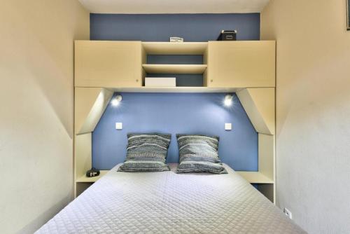 une chambre avec un lit avec deux oreillers dessus dans l'établissement Résidence Lacanau Les Pins - maeva Home - Appartement 2 pièces 6 personnes Sélection MAE-9142, à Lacanau