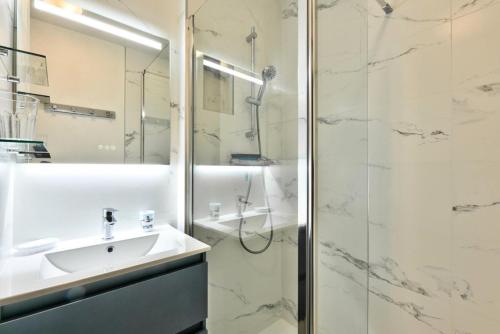 une salle de bain avec un lavabo et une douche dans l'établissement Résidence Lacanau Les Pins - maeva Home - Appartement 2 pièces 6 personnes Sélection MAE-9142, à Lacanau