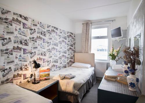a bedroom with a bed and a wall covered in photos at Monaco Hotel in Weston-super-Mare