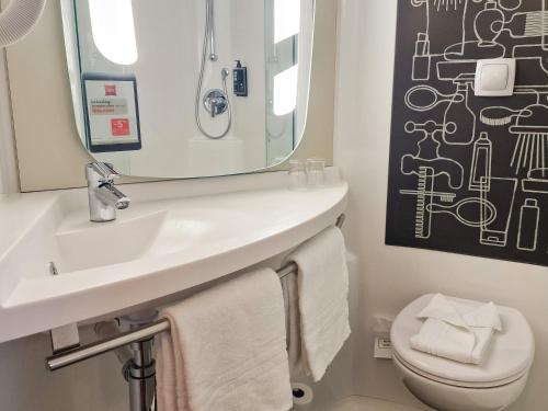 ein Badezimmer mit einem Waschbecken, einem WC und einem Spiegel in der Unterkunft Hotel ibis Dijon Centre Clemenceau in Dijon