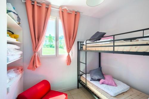 ein Zimmer mit zwei Etagenbetten und einem Fenster in der Unterkunft Les maisons Le Rouret - maeva Home - Maison 3 Pièces 6 Personnes - Sélection MAE-9200 in Grospierres
