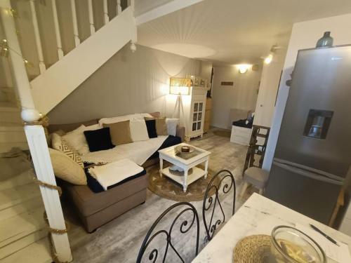ein Wohnzimmer mit einem Sofa und einer Treppe in der Unterkunft Appartement Cosy à 20 mètres de la plage in Royan