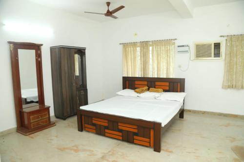 1 dormitorio con 1 cama y ventilador de techo en Thiruvallur Farm House, en Tiruvallūr