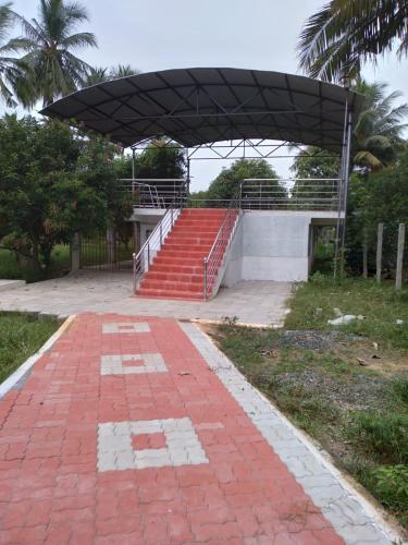 una pasarela de ladrillo rojo que conduce a un edificio con techo en Thiruvallur Farm House, en Tiruvallūr