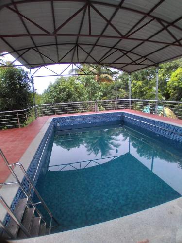 una gran piscina de agua azul en Thiruvallur Farm House, en Tiruvallūr