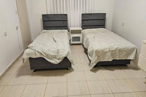 two beds sitting next to each other in a room at גדולה ומעוצבת ברעננה in Ra‘ananna