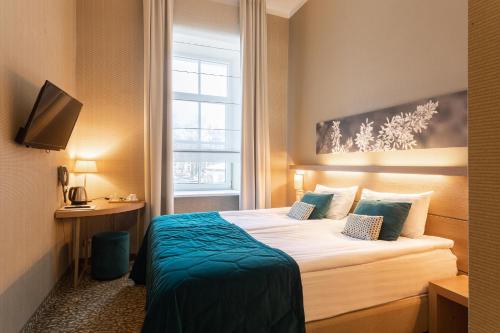 pokój hotelowy z łóżkiem i oknem w obiekcie City Hotels Algirdas w Wilnie