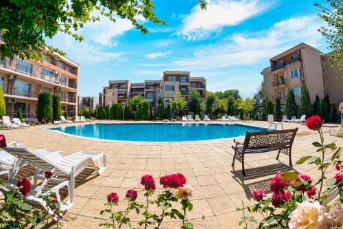 a swimming pool in a resort with chairs and flowers at Nessebar and Holiday Fort Apartments in Sunny Beach