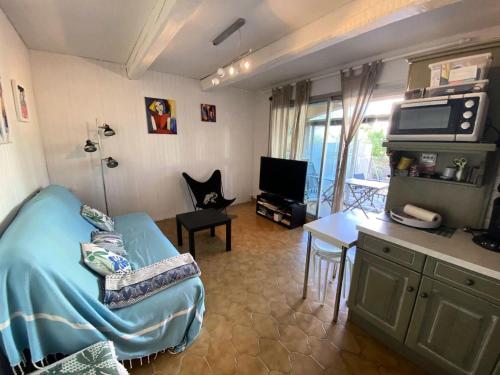 - un salon avec un lit, une table et une télévision dans l'établissement Résidence Marie Louise - Agréable appartement de 35m2 avec 4 couchages à Sanary-sur-Mer proche des plages MAE-9824, à Six-Fours-les-Plages