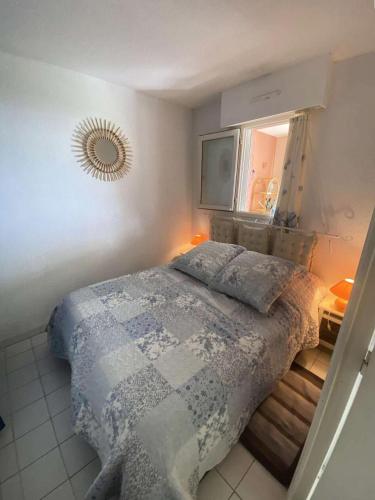 une chambre avec un lit et un miroir au mur dans l'établissement Résidence Morieres - Joli T2 6 couchages à Six Fours Les Plages vue mer exceptionnelle MAE-9934, à Six-Fours-les-Plages