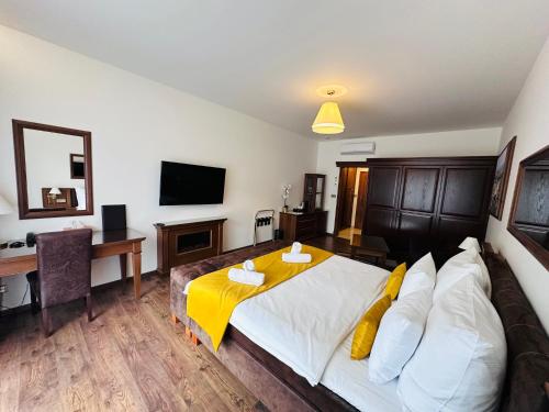a bedroom with a bed with a yellow blanket on it at Parkhotel Brno in Brno