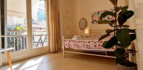 a bedroom with a bed and a large window at Next to Metro! Bright Apartment with Fully Equipped Kitchen in Athens