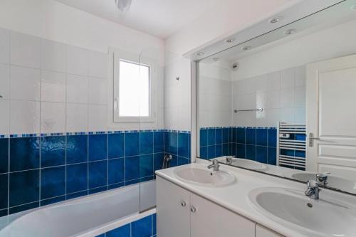 une salle de bain avec un lavabo, un miroir et une baignoire dans l'établissement Résidence Villa Marine - maeva Home - Appartement 3 Pièces 6 Personnes - Sélection MAE-2646, à Soulac-sur-Mer