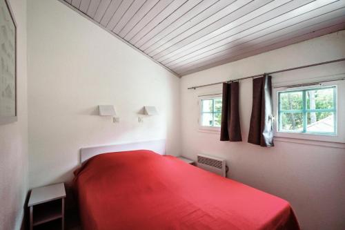 1 Schlafzimmer mit einem roten Bett und 2 Fenstern in der Unterkunft Village Moliets - maeva Home - Appartement 3 Pièces 7 Personnes - Sélection MAE-2750 in Moliets-et-Maa