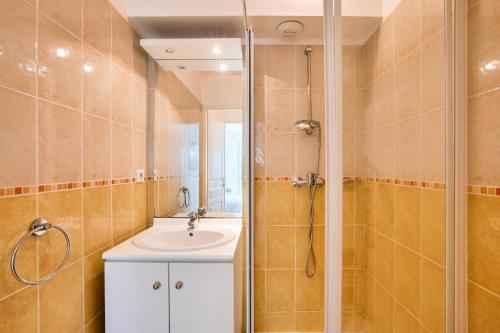 une salle de bain avec un lavabo et une douche dans l'établissement Résidence Villa Marine - maeva Home - Appartement 3 Pièces 6 Personnes - Confort MAE-3007, à Soulac-sur-Mer