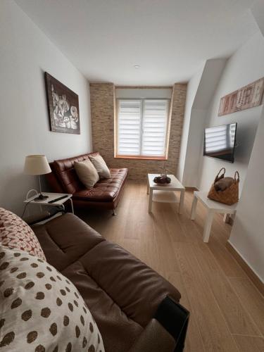 uma sala de estar com um sofá e uma mesa em Alojamientos Robustiana em Santander