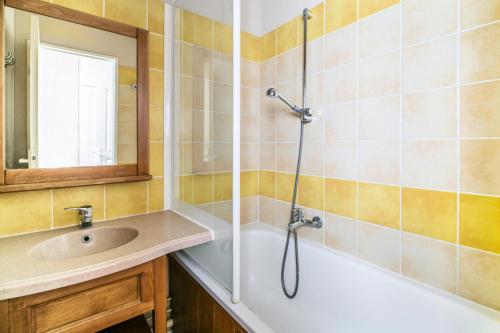 y baño con bañera, lavamanos y ducha. en Résidence Le Hameau du Lac - maeva Home - Appartement 2 Pièces 4 Personnes 95, en Marciac