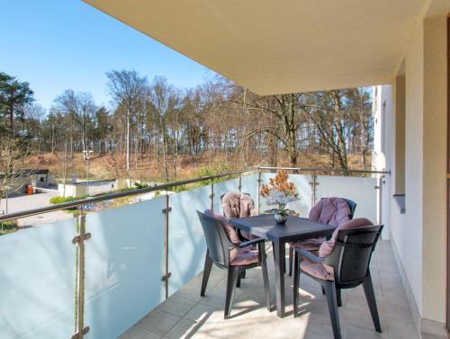 eine Terrasse mit einem Tisch und Stühlen auf dem Balkon in der Unterkunft Apartamenty Aquamarina SeaView by Rent like home in Misdroy