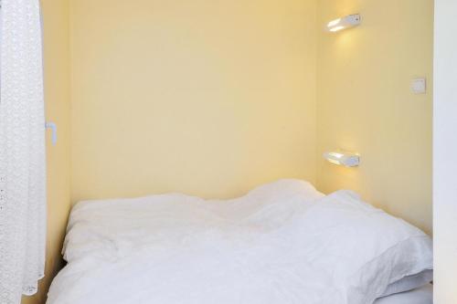 - un lit avec des draps blancs et des lumières sur le mur dans l'établissement Village Pont Royal en Provence - maeva Home - Studio 4 personnes - Confort MAE-2907, à Mallemort