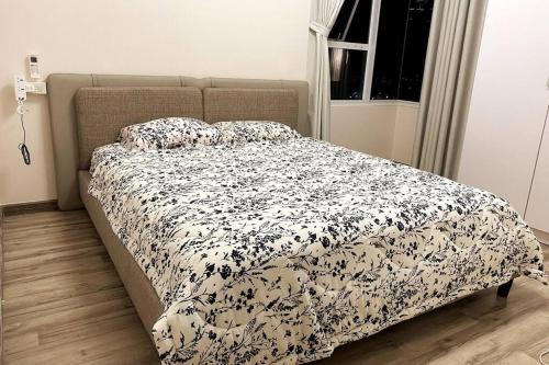 uma cama com um edredão preto e branco num quarto em Sora Gardens 1 em Xóm Bưng Ðìa